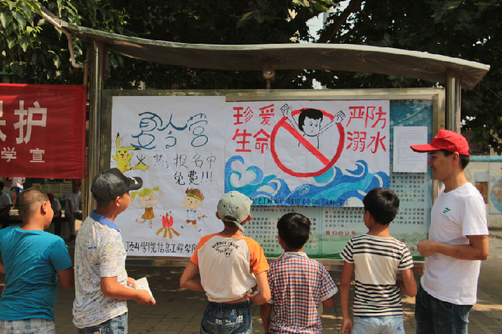 志愿者给员工讲解防溺水宣传海报(摄影 任双辉).JPG